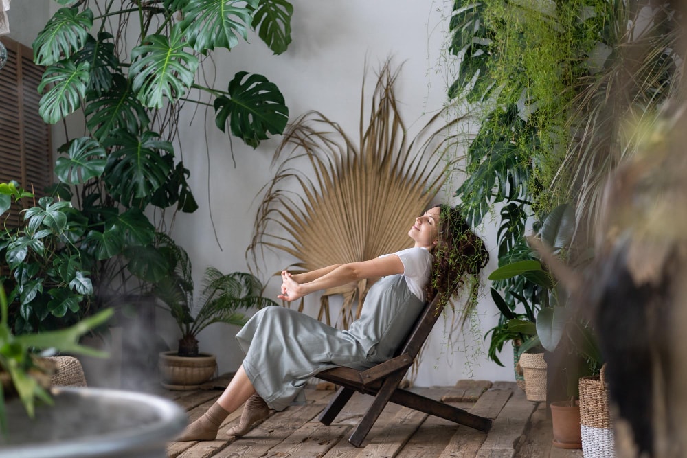 Woman relaxing in a plant-filled room